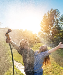 Couple enjoying pressurized water in garden.
