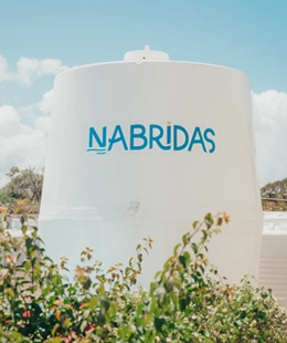 Giant fiberglass water tank in white with Nabridas logo on it.